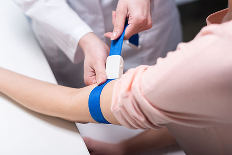 Medical professional applying tourniquet before blood draw — Dynacare Lab